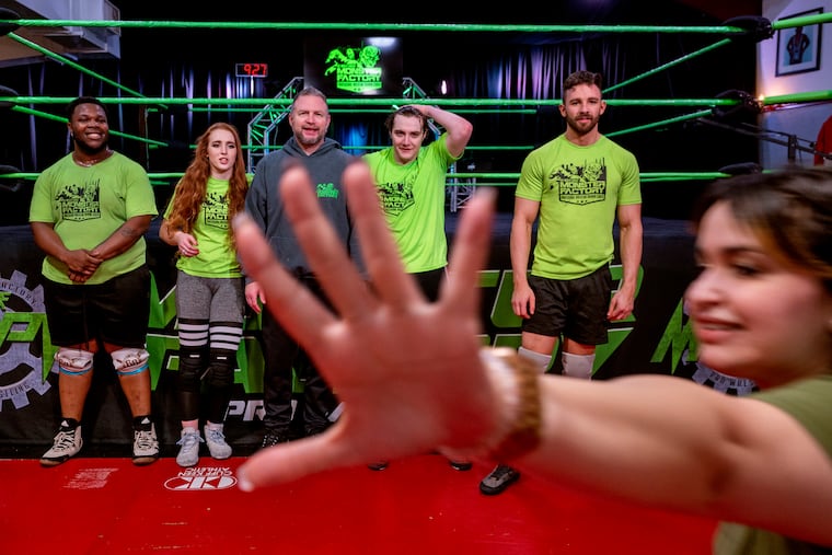Believing her fellow-wrestlers were doing a group photo without her, Gabby Ortiz blocks the photographer’s lens as she rushes to join them, posing at the Monster Factory, a pro wrestling school in Paulsboro.
