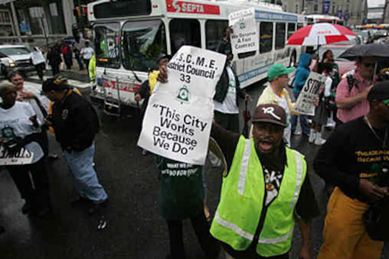 Protesters snarl traffic at 16th and JFK after rallying at LOVE Park. Four city union contracts expire at the end of June, including those with police officers and firefighters. (David Swanson / Staff )