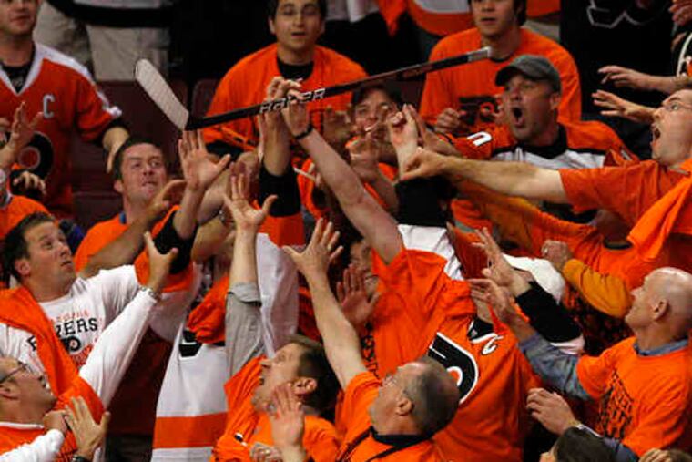 Fans reach for a hockey stick that the Flyers' Scott Hartnell tossed into the crowd Monday night, after the team topped the Canadiens, 4-2, to win the Eastern Conference title. Check out our six pages of sports coverage of the Flyers as they prepare for the heavily favored Chicago Blackhawks Saturday.