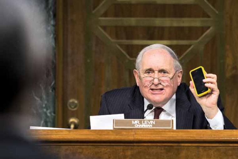 Senate Homeland Security and Governmental Affairs Permanent subcommittee on Investigations Chairman Sen. Carl Levin, D-Mich., holds up his own Apple iPhone, on Capitol Hill in Washington, Tuesday, May 21, 2013, as he presses Apple CEO Tim Cook for answers about how Apple, the world's most valuable company, and based in Cupertino, Calif., diverts a billion dollars to an Irish subsidiary as a tax strategy, according to a report issued this week by the subcommittee. (AP Photo/J. Scott Applewhite)