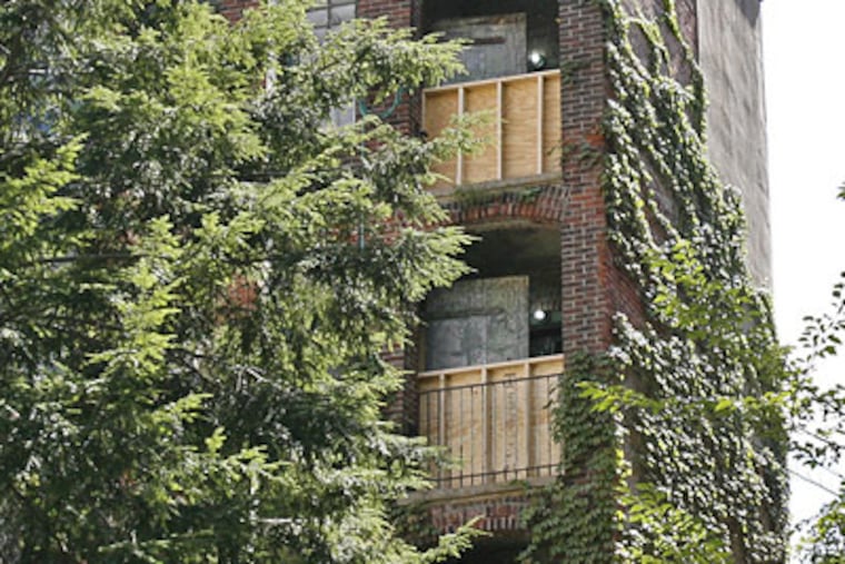The boarded-up area near the top of the building at 264 S. 16th St. is where the railing broke from the fire escape, leading to a man’s death. (Tom Gralish / Staff Photographer)