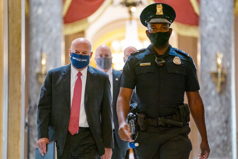Postmaster General Louis DeJoy, left, is escorted to House Speaker Nancy Pelosi’s office on Capitol Hill in Washington, Wednesday, Aug. 5, 2020. Some clarity is beginning to emerge from the bipartisan Washington talks on a huge COVID-19 response bill. An exchange of offers and meeting devoted to the Postal Service on Wednesday indicates the White House is moving slightly in House Speaker Nancy Pelosi’s direction on issues like aid to states and local governments and unemployment insurance benefits. But the negotiations have a long ways to go. (AP Photo/Carolyn Kaster).