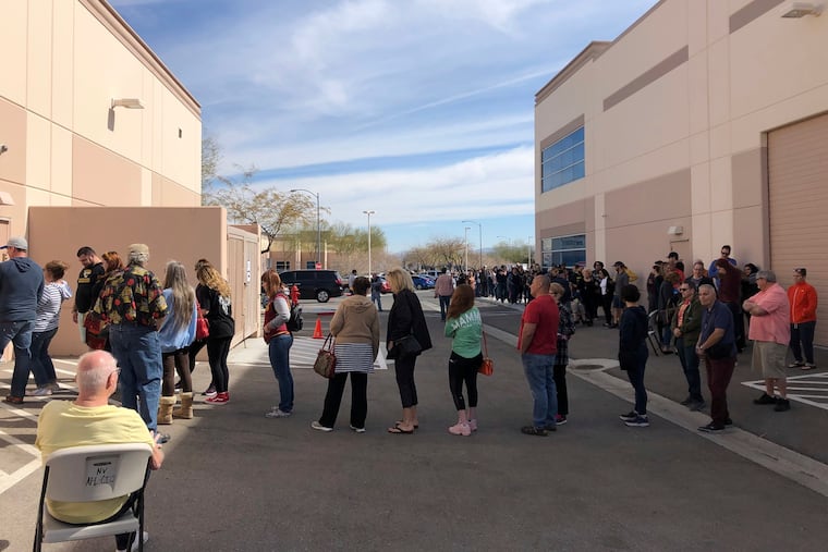 Democratic caucus-goers wait more than an hour in line in an early caucus ballot precinct site at an AFL-CIO union office in Henderson, Nev., Saturday, Feb. 15, 2020. Voters filled out ballots with first, second and third choice picks, to be tallied Saturday, Feb. 22, in the Nevada Democratic Party caucus.