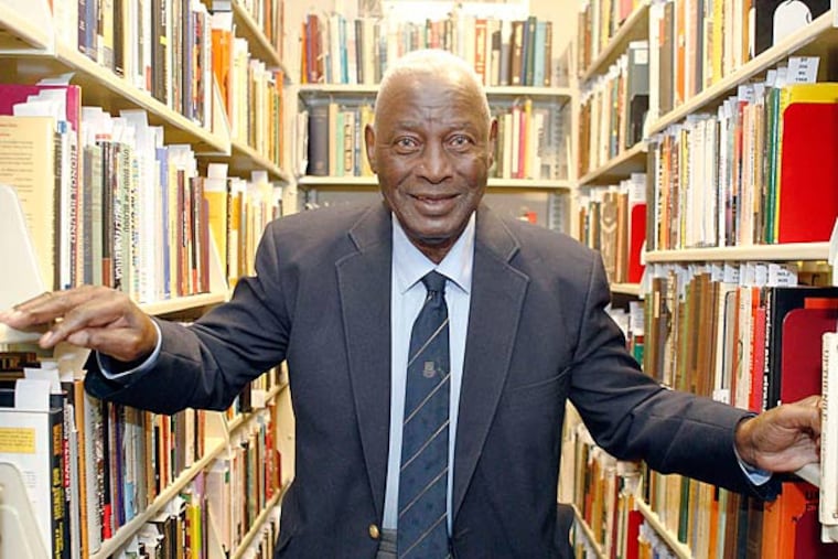 Charles L. Blockson among books in his collection at Temple. He also has gathered art and artifacts. AKIRA SUWA / Staff Photographer