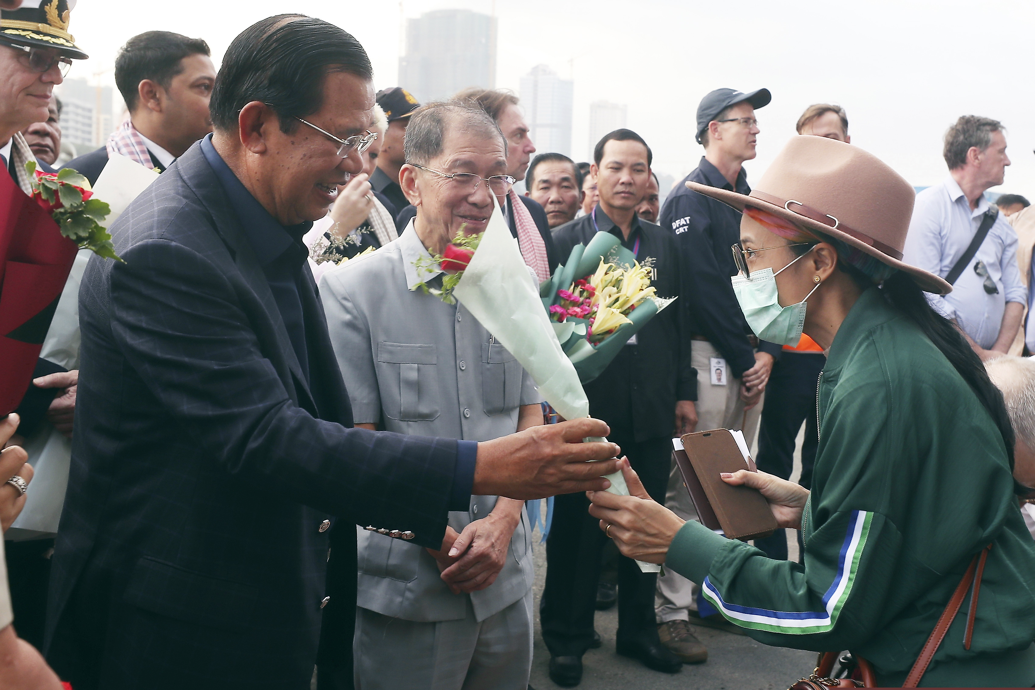 Cambodia's Prime Minister Hun Sen gives a bouquet of flowers to a passenger who disembarked from the MS Westerdam, owned by Holland America Line, at the port of Sihanoukville, Cambodia on Friday.
