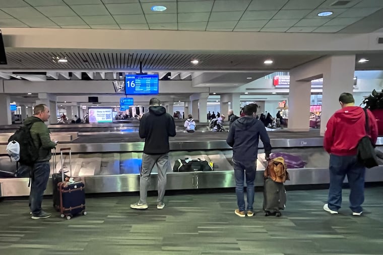 Travelers wait for their bags in Terminal C at Philadelphia International airport.