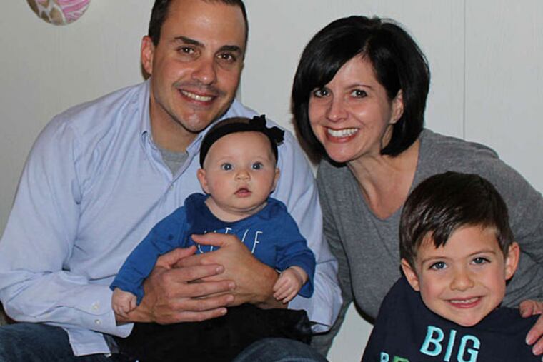 Nick Zikas holds Avery, and wife Amanda and son Owen complete a family portrait.