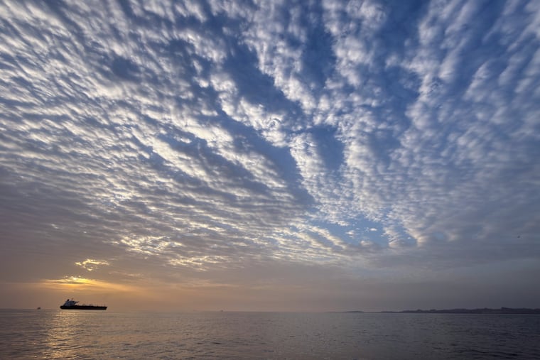 The sun rises behind a tanker anchored in the Strait of Hormuz off the coast of Qeshm Island, Iran, Saturday, April 18, 2026. (AP Photo/Asghar Besharati)