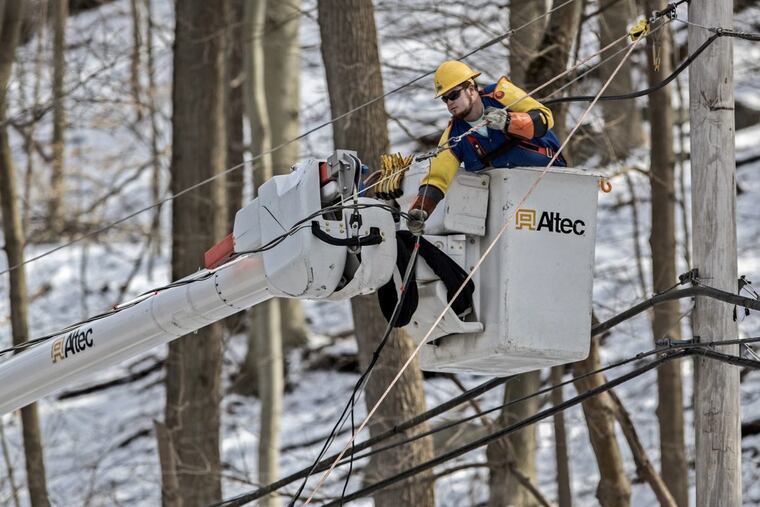 A lineman for PIKE electric company, from southern Maryland, pulls up a downed powerline on New Road in Aston on Thursday.