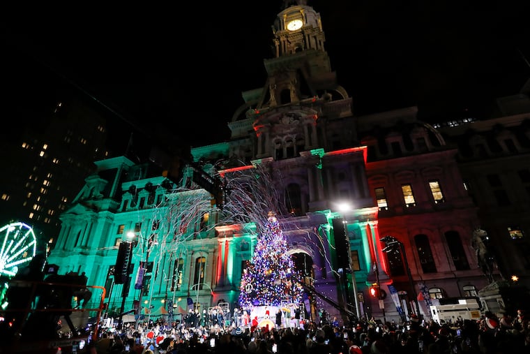Visitors watch the tree lighting ceremony at City Hall on Thursday.