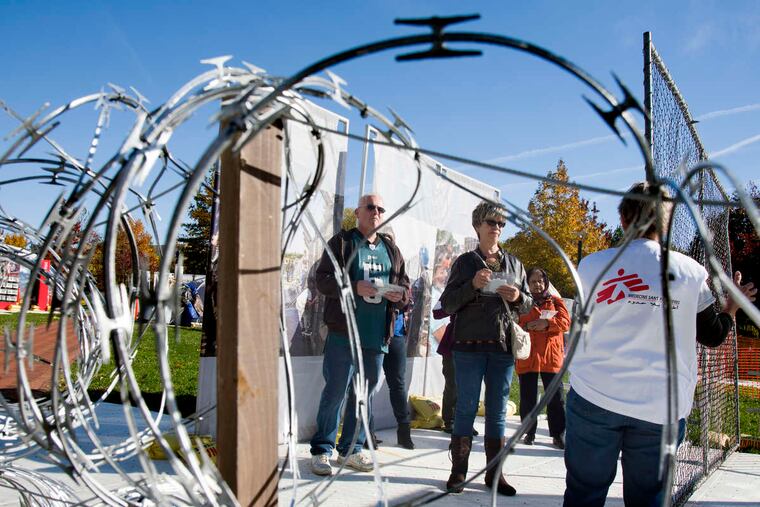 Doctors Without Borders guide Donna Canali (right) leads a tour through the refugee camp on Independence Mall. Aid workers guide visitors through the 10,000-sq-foot exhibit called Forced From Home.