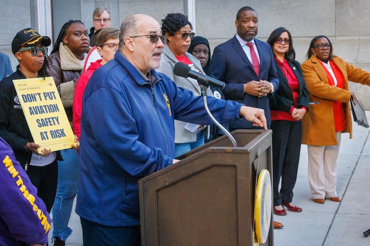 Phil Glover with the American Federation of Government Employees, which represents TSA workers in Pennsylvania and Delaware, speaking at the podium on the north side of City Hall in Philadelphia, Pa. on Thursday, March 26, 2026. City officials, TSA union leadership, and members of the clergy were there to support TSA workers who are working without pay during the DHS shutdown, and to seek removal of I.C.E officers from Philadelphia International Airport during a press conference. In the background, from left to right, are Democratic City Council President Kenyatta Johnson and Councilmember Nina Ahmad and, Councilmember Kendra Brooks of the Working Families Party.