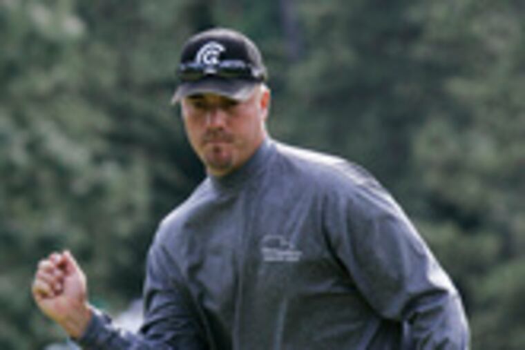 Brett Wetterich reacts as his putt drops for a birdie on the 17th green. He shares the lead at 3 under with Britain's Justin Rose.