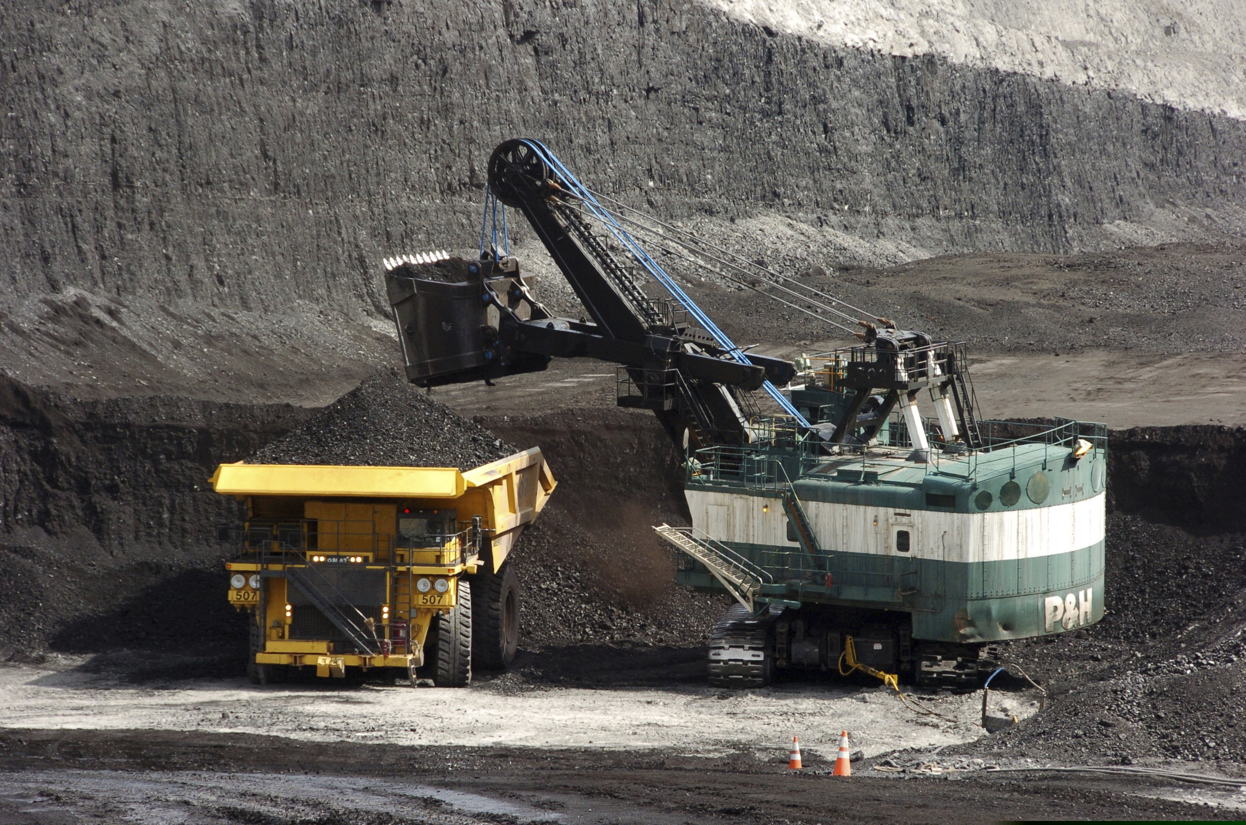 FILE - In this April 4, 2013, file photo, a mechanized shovel loads a haul truck with coal at the Spring Creek coal mine near Decker, Mont. A federal judge in Montana says the Trump administration failed to consider the environmental effects of resuming coal sales from federal lands, but stopped short of halting future sales. U.S. District Judge Brian Morris on Friday, April 19, 2019, ordered government attorneys to enter negotiations with states and environmental groups that had sued to stop the lease sales. (AP Photo/Matthew Brown, File)