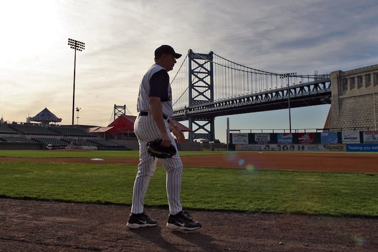 Camden Riversharks field manager Joe Ferguson walks on Campbell’s Field with the Benjamin Franklin Bridge in the background in Camden, N.J., on Thursday, May 3, 2007.
