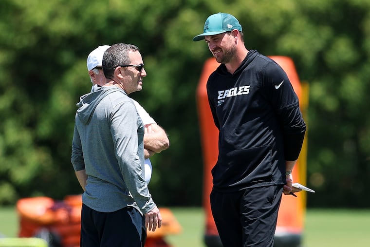 Jeffrey Lurie and Howie Roseman (left) speak with new Eagles offensive coordinator Sean Mannion, who will be a first time playcaller for the team this season.