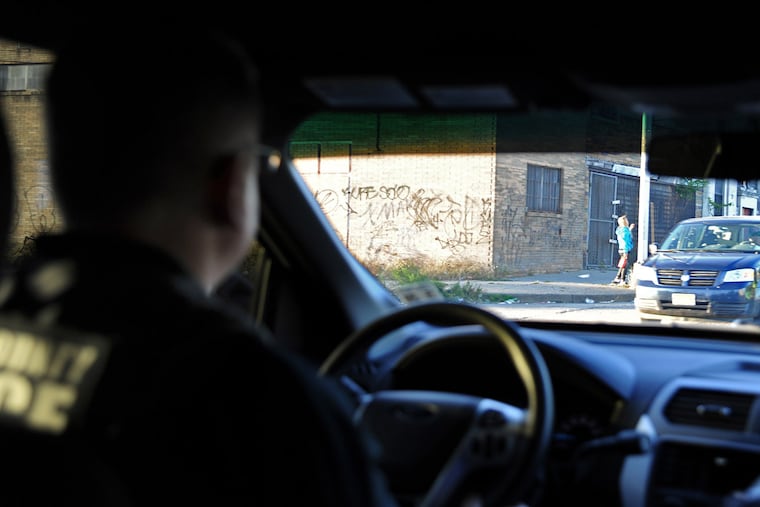 In his cruiser on Broadway, Camden County Police Detective Tom Collins passes a suspected prostitute.