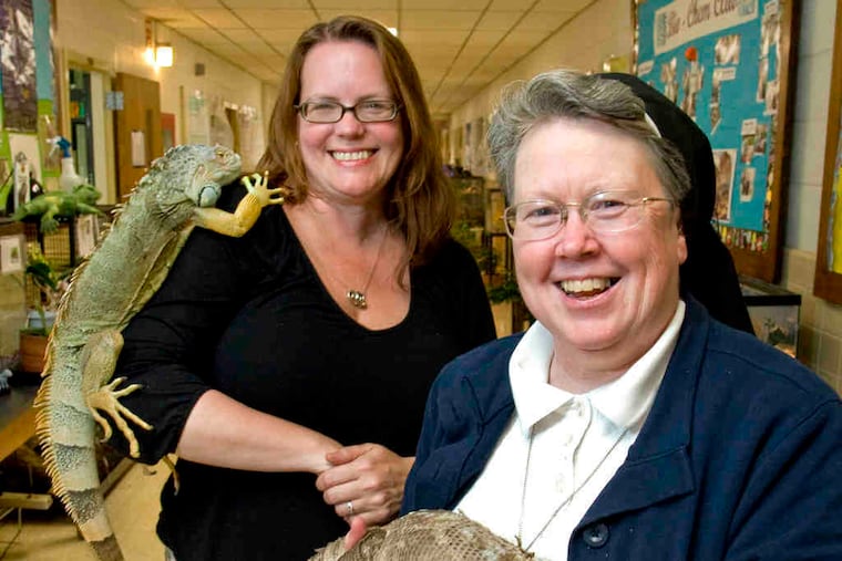 Sister Susan Cronin holds Gandalf the savannah monitor; Deb Tischler, lab manager, is with Indi the iguana. Far left, Georgia, albino leopard gecko. Left, Fluffy, a hairless guinea pig.