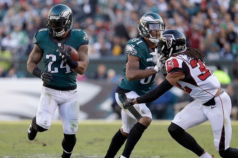Ryan Mathews runs with the football as teammate Jordan Matthews blocks Falcons cornerback Jalen Collins.