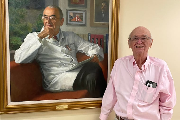 Dr. Baum stands by his portrait. He spent more than 50 years teaching, researching, administering, and caring for patients at Penn and its affiliates.