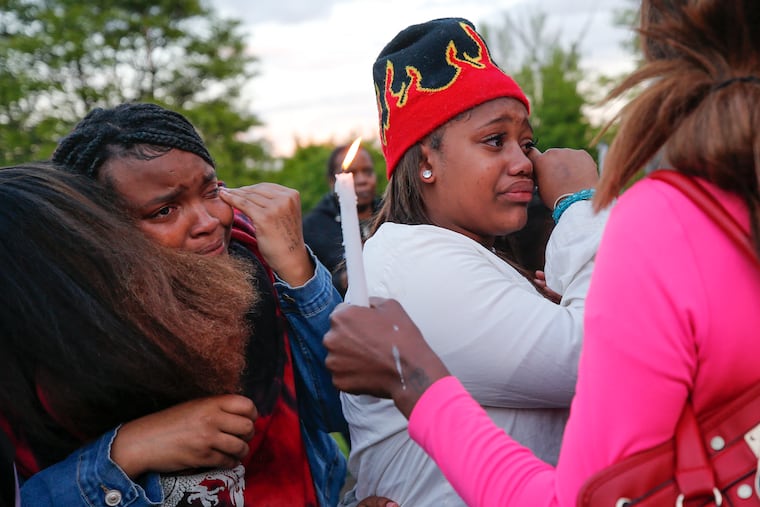 Aihyana Womack, 13, center, sister of Ahyir Womack, is embraced after balloons are released at a vigil for both Womack and Jahaad Atkinson at Martin Luther King Park in Chester, Pa. on May 5. The boys, who were 9 and 12 years-old, were killed after being struck by an Amtrak train last Saturday.