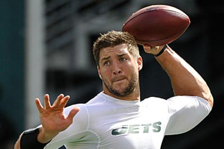 New York Jets quarterback Tim Tebow warms up before an NFL football game against the San Francisco 49ers. (Bill Kostroun/AP)