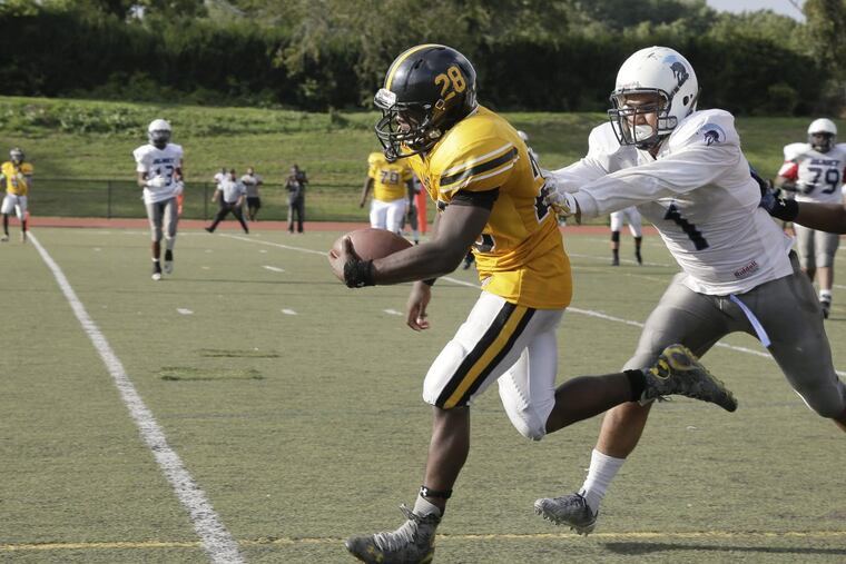 Lincoln’s Sammy Karr trying to escape the grasp of an Olney defender in a Public League game last season.