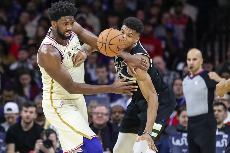Giannis Antetokounmpo is called for a foul against Joel Embiid in the second quarter of a game at the Wells Fargo Center in South Philadelphia on Wednesday, Dec. 25, 2019.