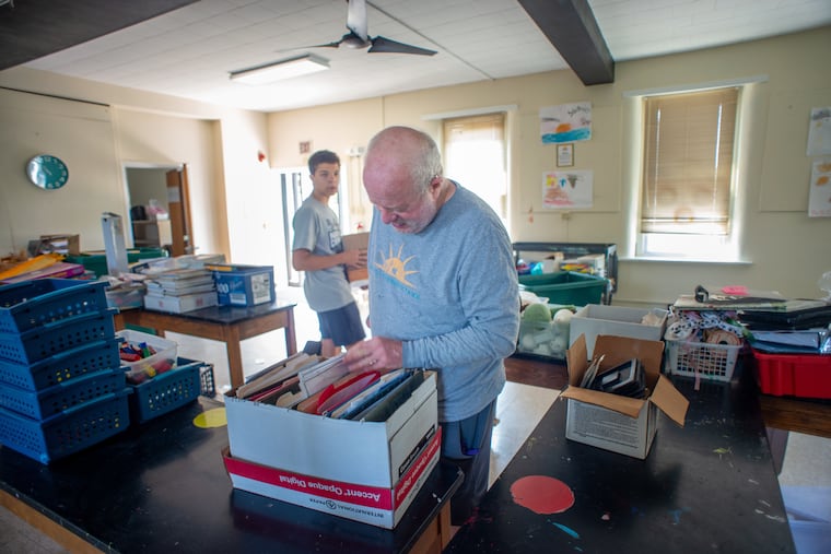 From left, Anthony Sacco, 16, a former student at United Friends School in Quakertown and school trustee Bob Wirtshafter help remove items from classrooms as volunteers clean out the school July 24.