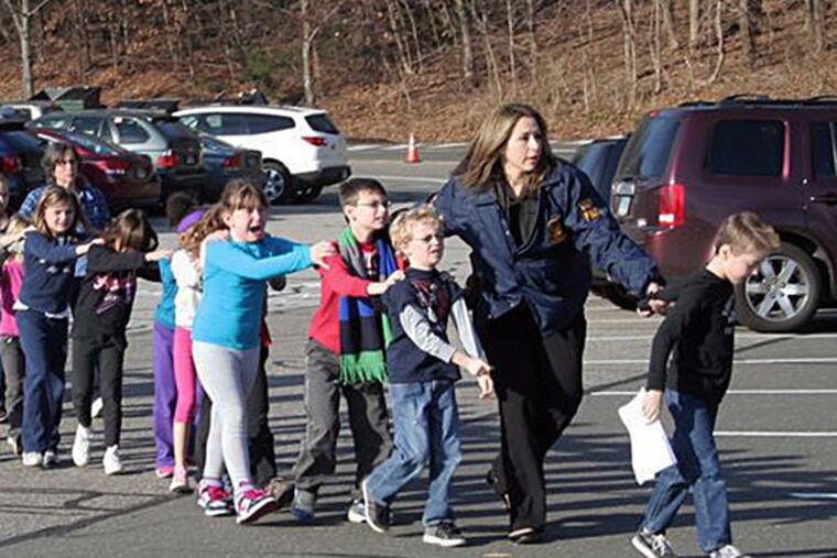 State police usher children away from Sandy Hook Elementary School in Newtown, Conn., after the shooting. SHANNON HICKS / Newtown Bee