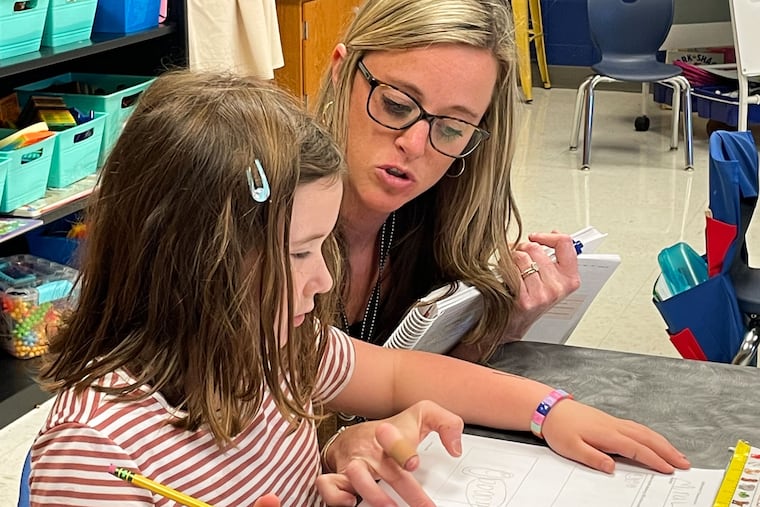 Hailey Lang at Burrus Elementary in Hendersonville, Tenn., helps a kindergarten student count up her circles and then translate those into numbers for an addition problem.