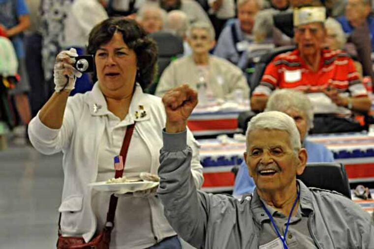 The Nj Veterans Memorial Home in Vineland, NJ was supposed to have a parade, but rain forced the festivities indoors on 5/11/13. Here, C. Anthony Confalone of Vineland raises his arm in a celebratory manner as the crowd sings happy birthday to Frank Cuccia, who turned 105 last month. ( APRIL SAUL / Staff )
