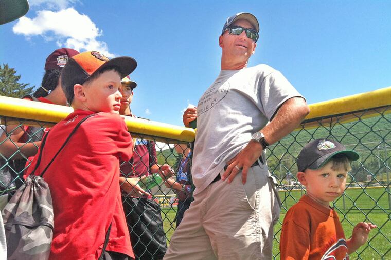 Kevin Lawrence and his son, Connor (left), 8, chat with Mo’ne Davis along the fence after the Taney Dragons held batting practice yesterday in South Williamsport.