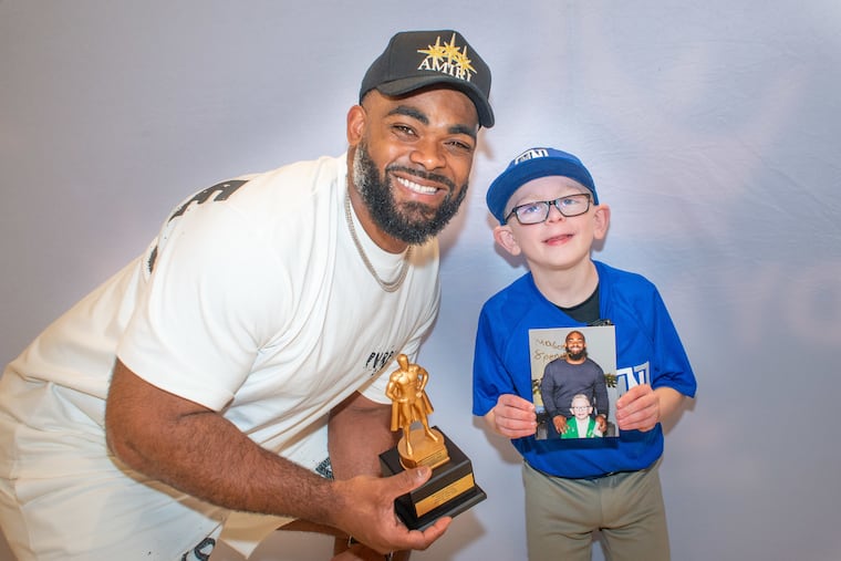 Mason Spencer (right), 8, of Langhorne, Pa. presented retired Philadelphia Eagles player Brandon Graham with the Mason Spencer Man of the Year award, which he made himself Saturday, April 19, 2025 at Oxford Valley Mall in Langhorne, . Graham missed out on the NFL’s Walter Payton Man of the Year Award, so Mason created his own award for his friend.