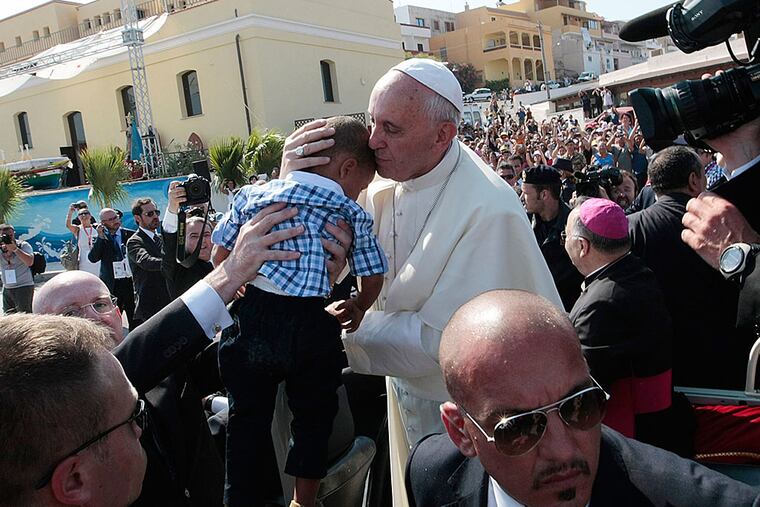 Pope Francis kisses a child in Lampedusa, an Italian island between Tunisia and Sicily where migrants wash ashore by the boatload. In his first trip outside Rome in 2013, he prayed for survivors of the crossing. (AP Photo/Gregorio Borgia)