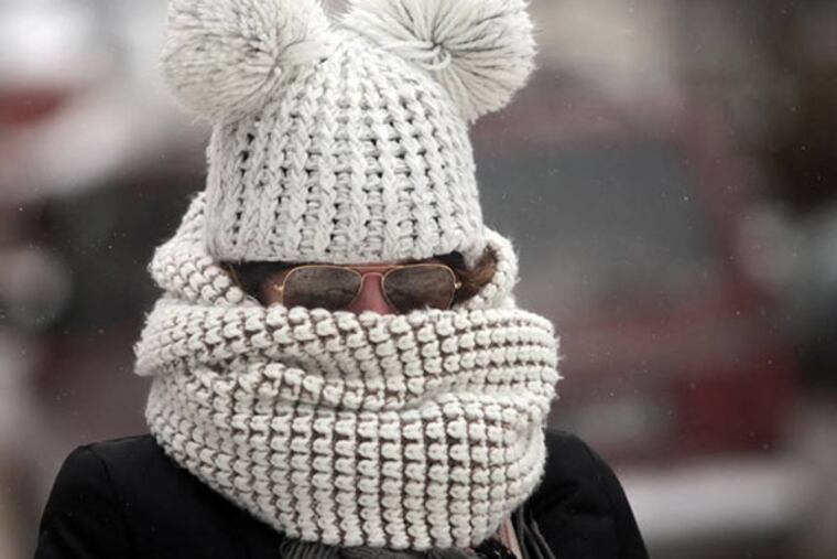 As frigid weather takes hold on the upper Midwest, Kristy Gruley of Madison, Wis. is well-bundled against the elements while walking in the city Friday, Jan. 3, 2014. (AP Photo, John Hart, Wisconsin State Journal)