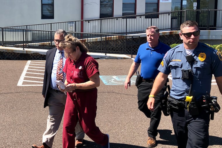 Ruth DiRienzo-Whitehead is escorted by police after her preliminary hearing Thursday. DiRienzo-Whitehead is accused of strangling her 11-year-old son to death in April.