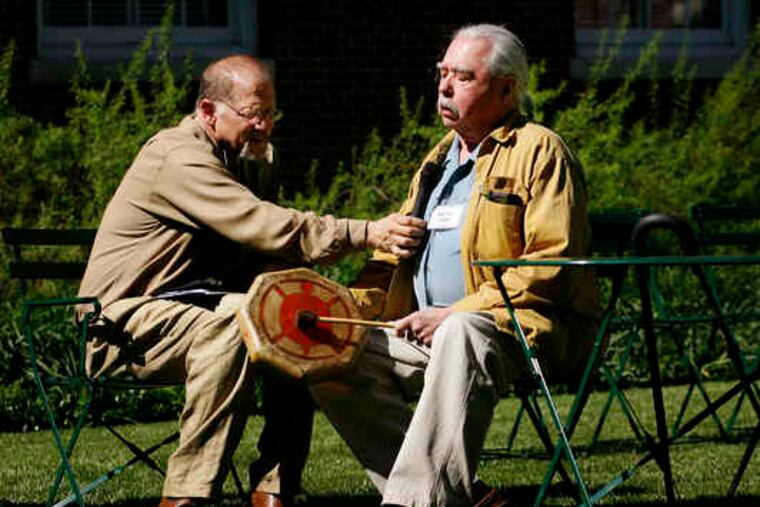 Timothy Powell, director of special American Indian projects for the American Philosophical Society, holds a microphone for Watie Akins of the Penobscot Nation during "Welcome Song."