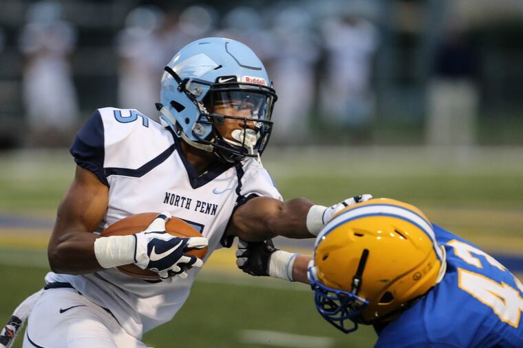 North Penn’s Justis Henley picks up yardage before being stopped by Downingtown East’s Stuart Regitz.