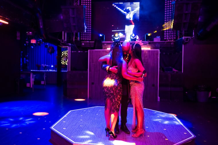 Dimitry Etienne (center) is embraced while speaking to guests during a memorial for Amadou Thiam as a video plays depicting his drag queen persona ‘Ama-Diva’ at Voyeur Nightclub on Saturday, Dec. 13, 2025 in Philadelphia.
