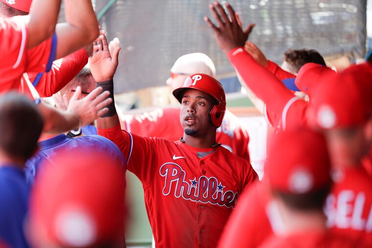 Phillies Jean Segura high-fives his teammates after scoring a run against the Pittsburgh Pirates in a spring training game at on Sunday.