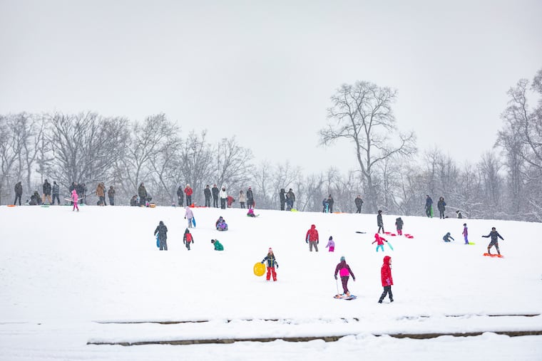 People gather at the Belmont Plateau to sled down the hill on a snowy day in West Philadelphia, Pa., on Friday, Jan. 19, 2024.