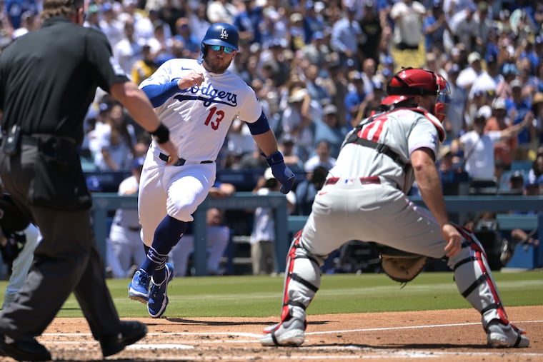 The Dodgers' Max Muncy (13) beats a throw to Phillies catcher J.T. Realmuto for a run during the second inning on Sunday.