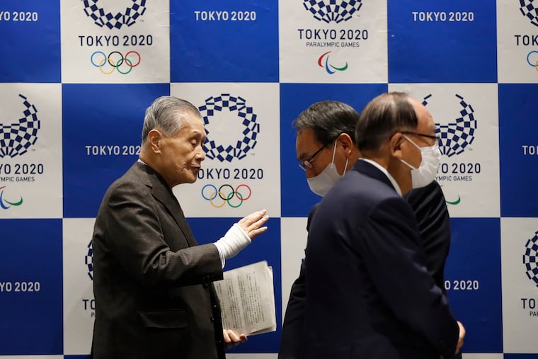 Tokyo Olympic President Yoshiro Mori, left, talks with other board members wearing protective face masks upon arrival at the Tokyo 2020 Executive Board Meeting in Tokyo on Monday