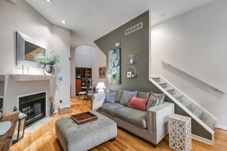 Behind the historic brick facade is a living room with hardwood floors, 14-foot ceilings, and a versatile layout opening into the dining area.