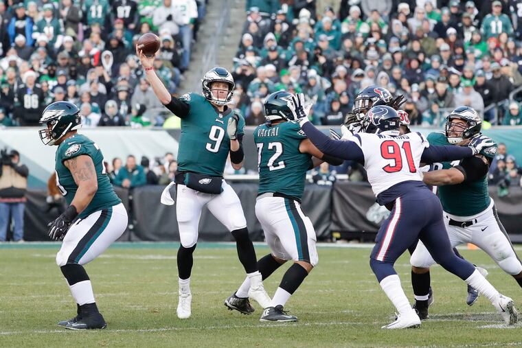 Eagles quarterback Nick Foles throws the football with offensive lineme Brandon Brooks, Halapoulivaati Vaitai and Stefen Wisniewski against Houston Texans outside linebacker Jadeveon Clowney and Houston Texans defensive end Carlos Watkins on Sunday, December 23, 2018 in Philadelphia. YONG KIM / Staff Photographer