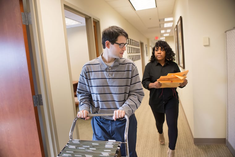 Neurodivergent mailroom employees Jeremy Zapor (left) and Nicole Henderson have worked at Harmelin Media in Bala Cynwyd for eight years.