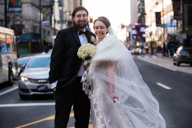 Niamh Farrell and Matt Soderblom cross Market Street on their way back to Loews Hotel after bridal party photos at City Hall.