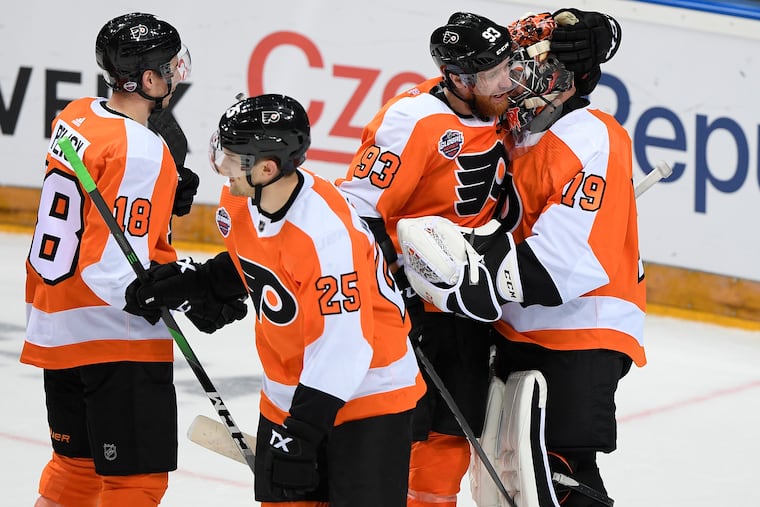 The Flyers, from left, Tyler Pitlick, James van Riemsdyk, Jake Voracek and Carter Hart, celebrate Friday after they beat the Chicago Blackhawks 4-3 in an NHL Global Series in Prague, Czech Republic. (Ondrej Deml/CTK via AP)