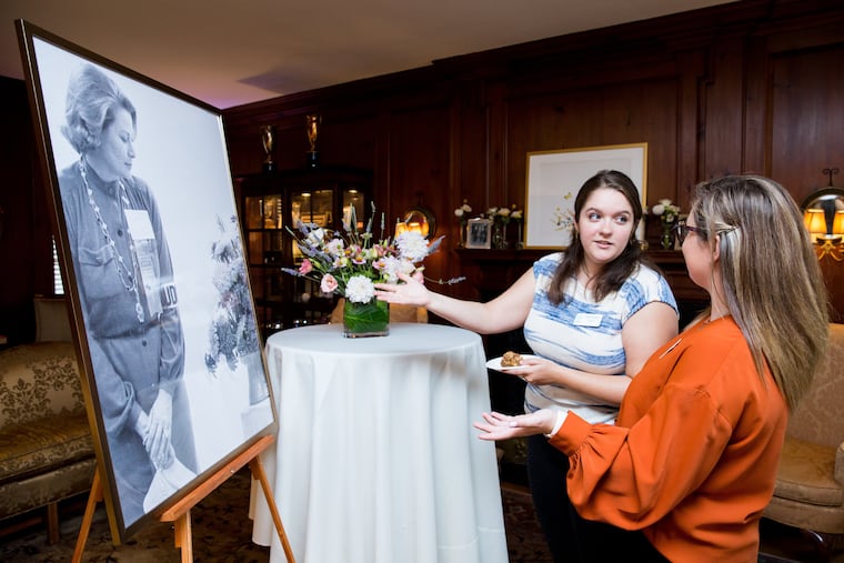 Two attendees of the Philadelphia Flower Show theme reveal look at a portrait of Princess Grace Kelly.